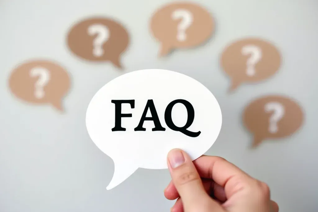 Hand hält eine Sprechblase mit dem Aufdruck 'FAQ', während im Hintergrund unscharfe Fragezeichen-Symbole erscheinen.
